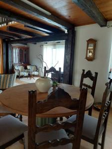 uma sala de jantar com uma mesa de madeira e cadeiras em Hilltop House. em Erdut