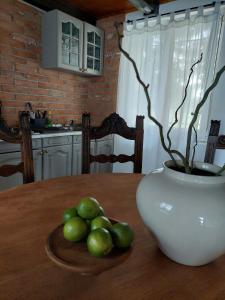 una mesa de madera con un jarrón y un plato de fruta en Hilltop House. en Erdut