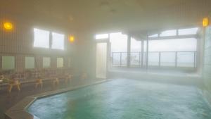 a large swimming pool in a building with a large window at Toba ryokan michishio in Toba