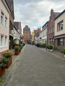 an empty street in a town with buildings and plants at Ferienwohnung Via Callidus in Xanten