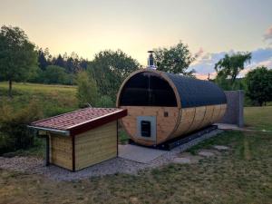 a small dog house sitting in the middle of a field at Maison avec piscine, jacuzzi et sauna in Saint-Nabord