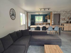 a living room with a couch and a dining room at Maison avec piscine, jacuzzi et sauna in Saint-Nabord