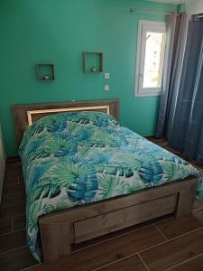 a bed in a bedroom with a blue wall at Maison avec piscine, jacuzzi et sauna in Saint-Nabord