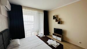 a bedroom with a bed and a large window at Akrotiria Beach Apart Complex in Nesebar