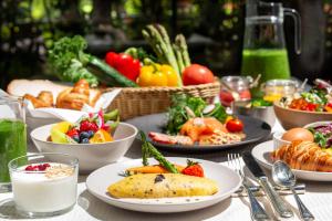 a table with plates of food and bowls of fruits and vegetables at The Westin Gurgaon, New Delhi in Gurgaon