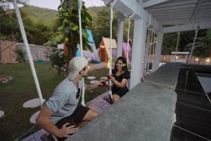 a man and a woman sitting on a porch swing at La Vie en Rose in Senggigi