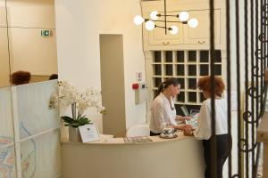 twee vrouwen aan een balie in een salon bij Vila Perast Boutique Hotel in Perast