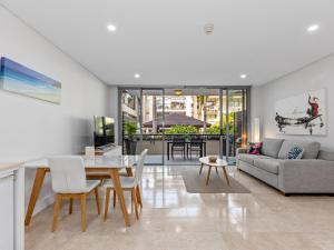 a living room with a table and a couch at Santai Resort - Holiday Management in Kingscliff