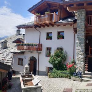 a white house with a balcony on top of it at Duanita appartamenti in La Salle