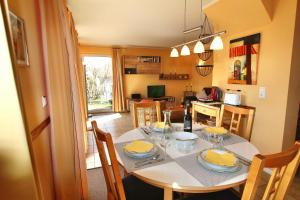 Una cocina y un comedor con mesa y sillas. en Ferienhaus CASA UNO, en Göhren-Lebbin