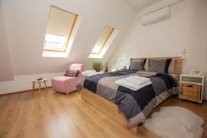 1 dormitorio con 1 cama grande y 1 silla rosa en Charming Apartment in Shtip's downtown, en Štip