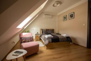 1 dormitorio con 1 cama y 1 silla en el ático en Charming Apartment in Shtip's downtown, en Štip