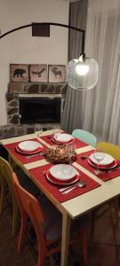 une table à manger avec une nappe rouge, des assiettes et des verres dans l'établissement Cottage in traditional village Bradulet, Arges county, à Brăduleţ 83 autres photos