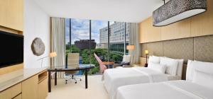 een hotelkamer met 2 bedden en een bureau bij The Westin Gurgaon, New Delhi in Gurgaon