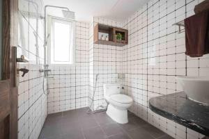 uma casa de banho em azulejos brancos com um WC e um lavatório em HIDDEN GEM*HEART of THE OLD QUARTER*5BR*FULL HOUSE em Hanói
