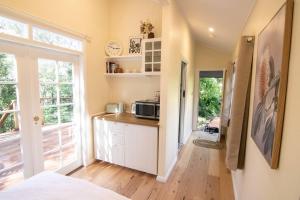a kitchen with a microwave on a counter in a room at Bottlebrush Cabin, cosy private cabin in the trees in Leura