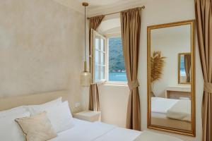 a bedroom with a bed and a mirror at Vila Perast Boutique Hotel in Perast