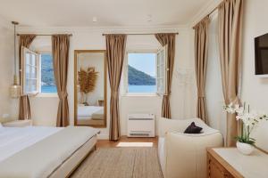 a bedroom with a bed and a chair and a mirror at Vila Perast Boutique Hotel in Perast +57 photos