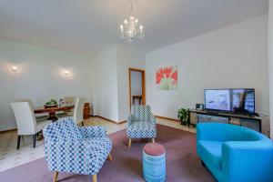 un soggiorno con divano blu e sedie di The Bon'Ora Apartment - Happy Rentals a Riva del Garda