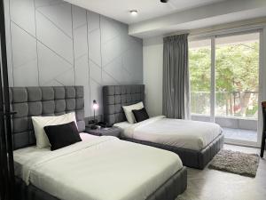 a bedroom with two beds and a large window at BedChambers Luxurious Serviced Apartment in Gurgaon in Gurgaon