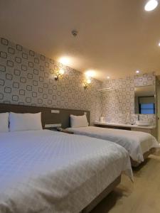 a bedroom with two beds and a mirror at Taiwan Seven Days Boutique Hotel in Taipei
