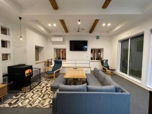 a living room with a couch and a table at Blueberry Apartment in Iiyama