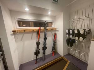 a room with hockey sticks hanging on a wall at Blueberry Apartment in Iiyama