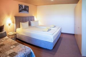 ein Hotelzimmer mit einem Bett und 2 Betten sidx sidx sidx sidx in der Unterkunft Hotel Thüringenschanze in Oberhof