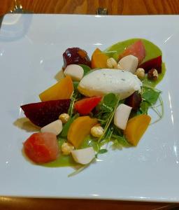 un plato blanco de comida con frutas y hortalizas en The Black Lion Royal Hotel en Lampeter