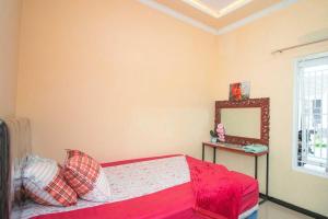 un dormitorio con una cama y un espejo en Villa Kencana with Balcony Mountain View, en Batu