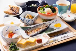 una mesa con platos de comida y tazones de comida en Ofunato Onsen, en Ōfunato