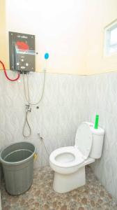 Un pequeño baño con inodoro y ducha. en Villa Kencana with Balcony Mountain View, en Batu