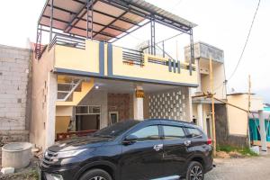 Un coche negro aparcado delante de un edificio en Villa Kencana with Balcony Mountain View, en Batu 2 fotos más