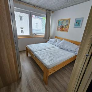 małą sypialnię z łóżkiem z oknem w obiekcie Apartmány Pstruží AP19 w mieście Pstruží