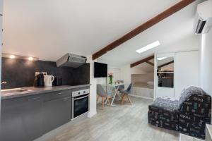eine Küche und ein Wohnzimmer mit einem Sofa und einem Tisch in der Unterkunft Appartements les Lions in Nizza