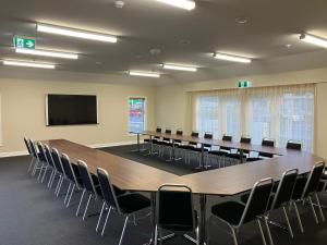 een grote vergaderzaal met een grote tafel en stoelen bij Newina Rotorua in Rotorua