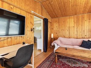 een woonkamer met een bank en een flatscreen-tv bij Holiday home Faxe Ladeplads IX in Fakse Ladeplads
