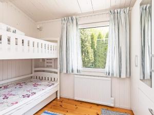 een kinderkamer met een stapelbed en een raam bij Holiday home Faxe Ladeplads IX in Fakse Ladeplads