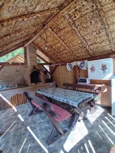 mesa y sillas en una habitación con techo en Căbănuțe Izbândiș en Şuncuiuş