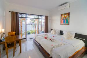 a bedroom with a bed and a desk and a window at Goa Giri Hill Bungalow in Nusa Penida