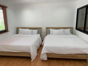 two beds sitting next to each other in a bedroom at Cozy House บ้านพักริมหาดบางแสน in Ban Bang Saen (1)