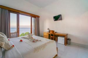 a bedroom with a bed with a view of the ocean at Goa Giri Hill Bungalow in Nusa Penida