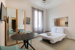 Kleines Zimmer mit einem Bett und einem Tisch in der Unterkunft Appartements les Lions in Nizza