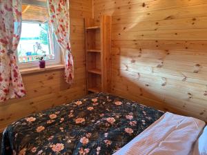 sypialnia z łóżkiem w drewnianym domku w obiekcie Domek 4-6osobowy w mieście Wroceń