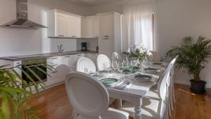 a white dining room with a white table and chairs at Val Piana in Savudrija