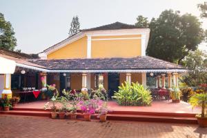 una casa con muchas flores delante de ella en Granpa's Inn Hotel Bougainvillea, en Anjuna