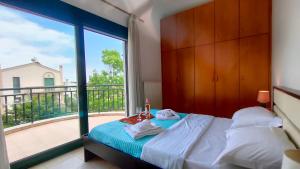 a bedroom with a bed and a large window at Alex House Garden in Iraklitsa