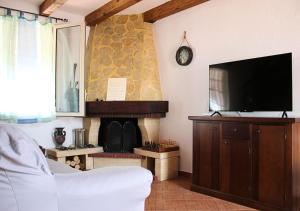 sala de estar con TV y chimenea en Villa Finestra sul Castello, en Partinico