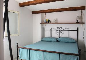 1 dormitorio con 1 cama con almohadas azules en Villa Finestra sul Castello, en Partinico