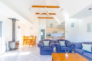 a living room with two blue couches and a table at Nannys Beach House in Berrara